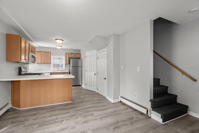 78-82 3rd St, Lowell, MA 01850 - kitchen with freestanding refrigerator, a baseboard heating unit, range, a peninsula, and light countertops