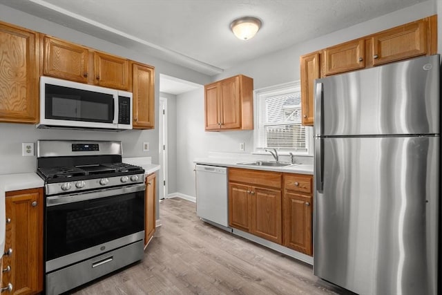 78-82 3rd St, Lowell, MA 01850 - kitchen featuring stainless steel appliances, light countertops, light wood-style flooring, and brown cabinetry