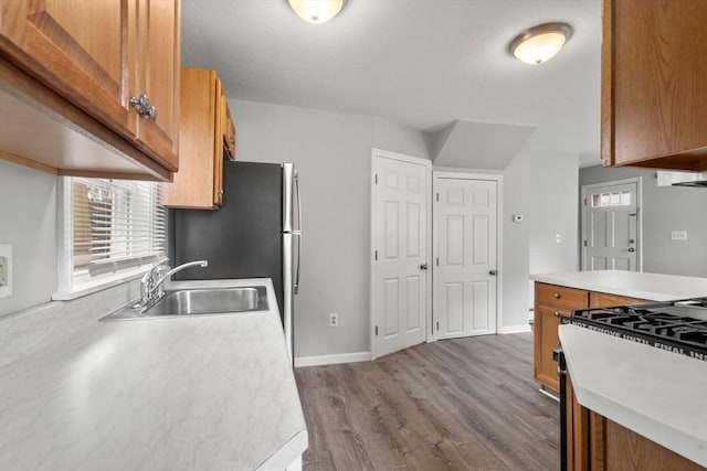 78-82 3rd St, Lowell, MA 01850 - kitchen featuring brown cabinetry, wood finished floors, light countertops, and range