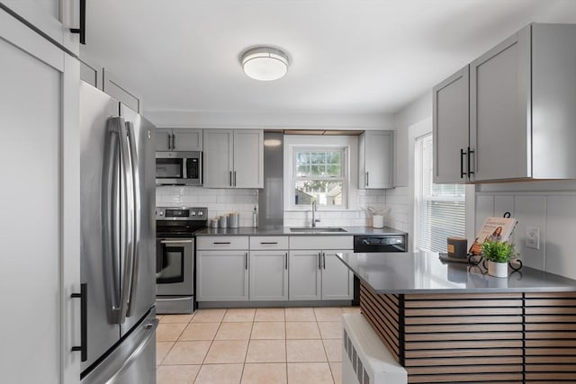 21 Ames, Lynn, MA 01905 - kitchen with stainless steel appliances, gray cabinets, decorative backsplash, light tile patterned floors, and dark countertops