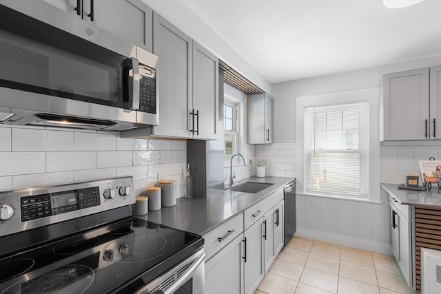 21 Ames, Lynn, MA 01905 - kitchen featuring appliances with stainless steel finishes, tasteful backsplash, gray cabinets, and light tile patterned floors