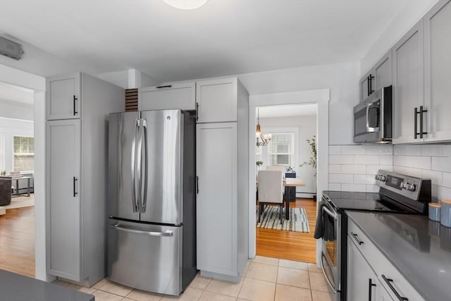 21 Ames, Lynn, MA 01905 - kitchen featuring stainless steel appliances, tasteful backsplash, a chandelier, and light tile patterned floors