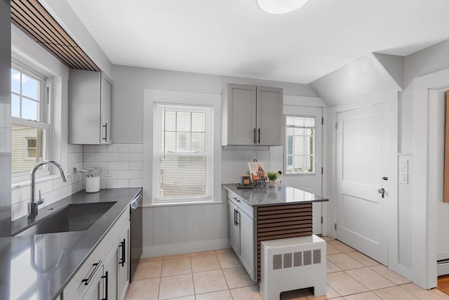 21 Ames, Lynn, MA 01905 - kitchen with gray cabinetry, stainless steel dishwasher, stainless steel counters, backsplash, and radiator heating unit