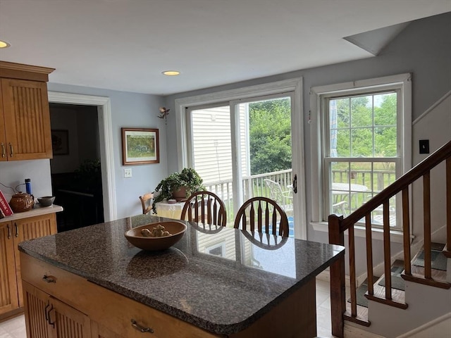 kitchen with a kitchen island and dark stone countertops