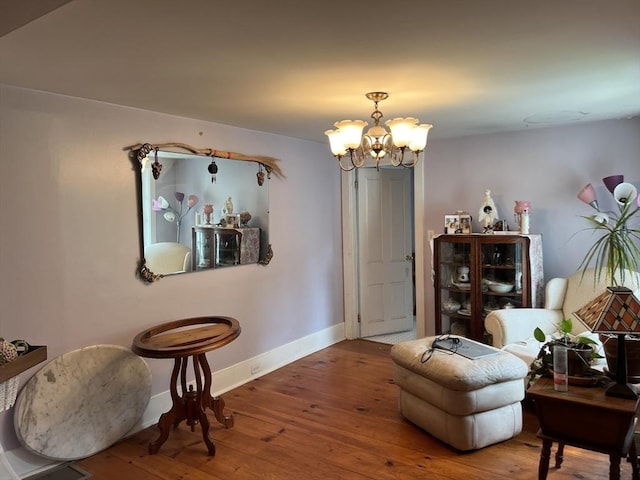 sitting room featuring a notable chandelier and hardwood / wood-style flooring