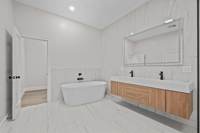 bathroom featuring a tub to relax in and vanity