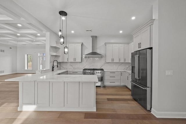 kitchen with coffered ceiling, wall chimney range hood, beamed ceiling, premium appliances, and kitchen peninsula