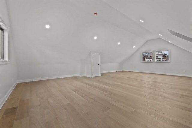 bonus room with light hardwood / wood-style floors and vaulted ceiling