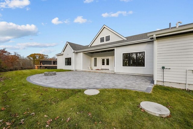 rear view of property with a patio, a fire pit, and a lawn