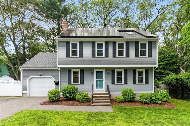 6 Flagg Dr, Framingham, MA 01702 - view of front of property with a garage, a chimney, driveway, roof mounted solar panels, and roof with shingles