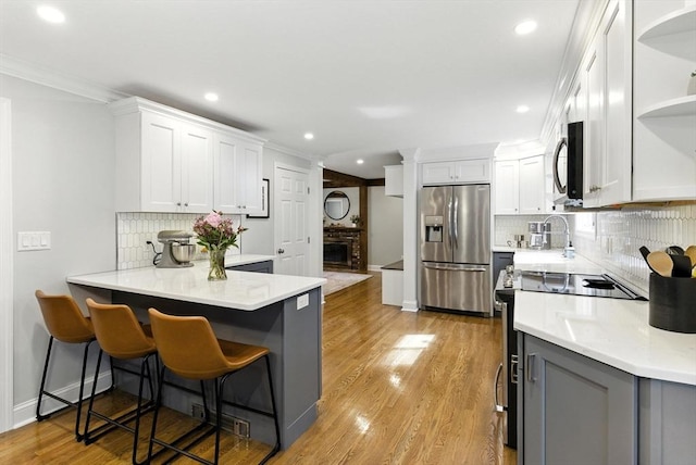 6 Flagg Dr, Framingham, MA 01702 - kitchen featuring stainless steel appliances, open shelves, a peninsula, tasteful backsplash, and white cabinetry