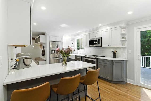 6 Flagg Dr, Framingham, MA 01702 - kitchen with stainless steel appliances, open shelves, gray cabinets, a peninsula, and tasteful backsplash