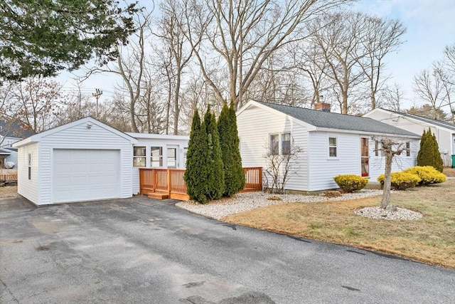 view of side of property featuring an outbuilding, a deck, and a garage