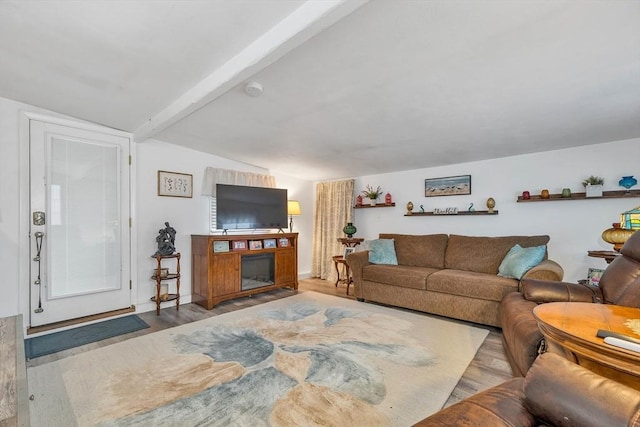 living room with light wood-type flooring and vaulted ceiling with beams