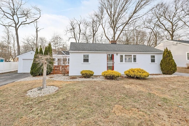 view of front of house featuring a garage, an outbuilding, and a front yard