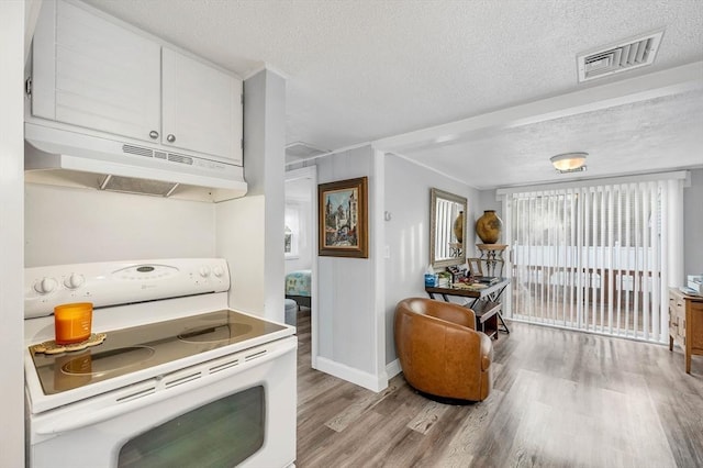 kitchen with light hardwood / wood-style flooring, white cabinets, a textured ceiling, and white electric range