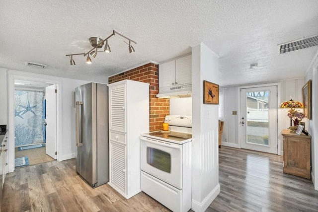 kitchen with white electric range oven, high end refrigerator, light wood-type flooring, and a textured ceiling