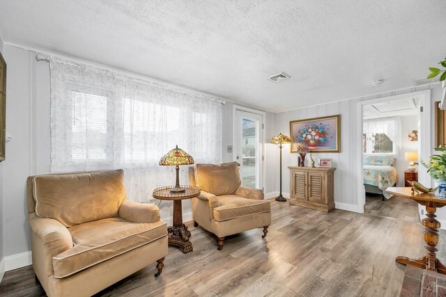 living area with hardwood / wood-style floors and a textured ceiling