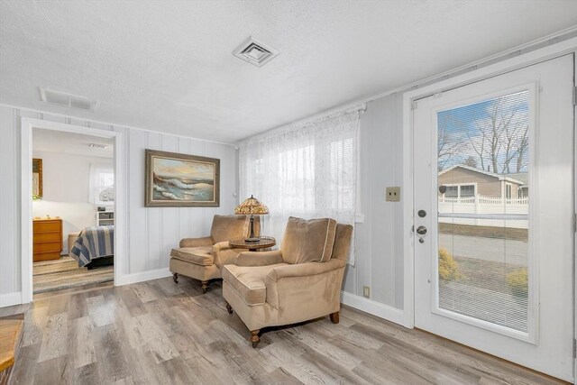 sitting room featuring light hardwood / wood-style floors and a textured ceiling