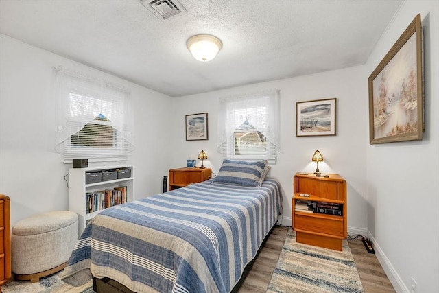 bedroom featuring dark hardwood / wood-style flooring and a textured ceiling