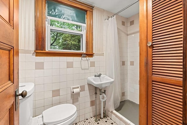 full bath with toilet, tile walls, a stall shower, tile patterned floors, and a closet