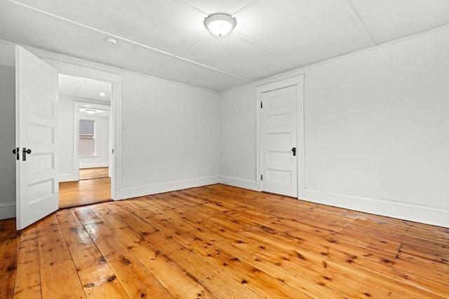 spare room with hardwood / wood-style floors and baseboards