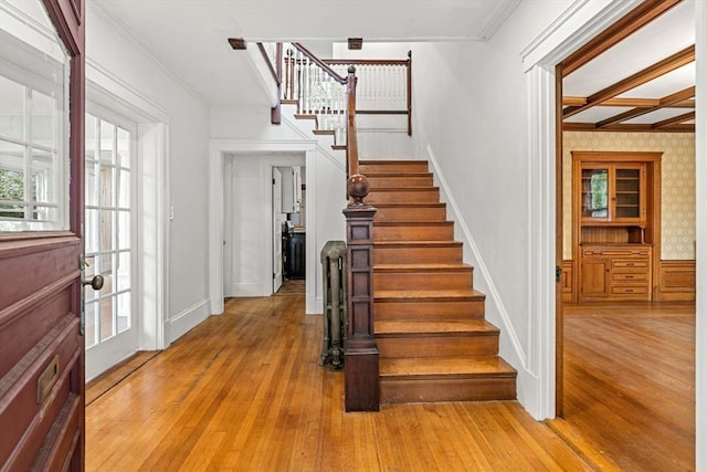foyer entrance featuring stairway, crown molding, light wood-style floors, and coffered ceiling
