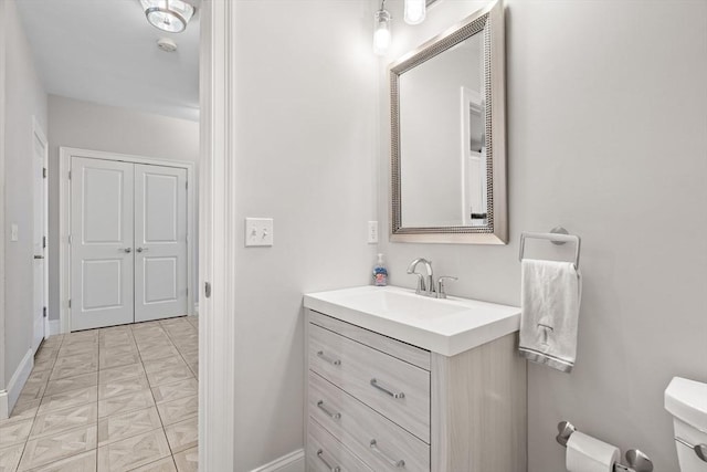 bathroom with vanity, toilet, and baseboards