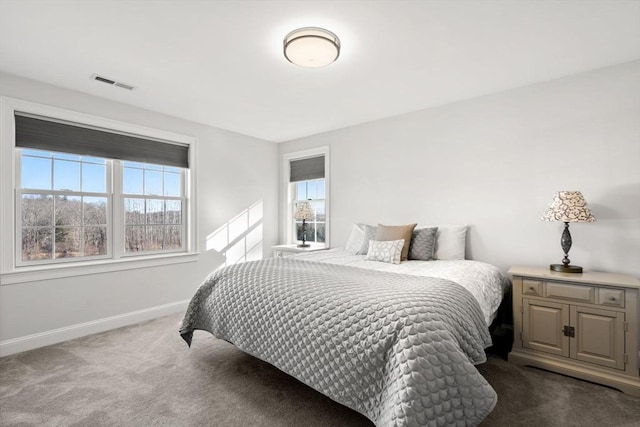 bedroom with baseboards, visible vents, and dark colored carpet