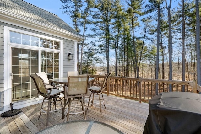 deck with outdoor dining space and area for grilling