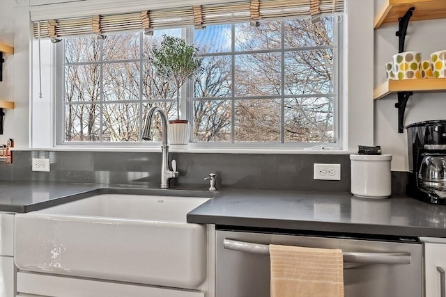 kitchen featuring sink, dishwasher, white cabinetry, and a wealth of natural light