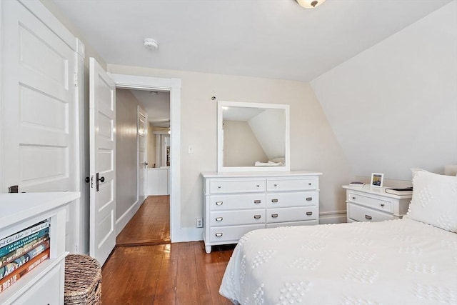 bedroom with lofted ceiling and dark hardwood / wood-style flooring