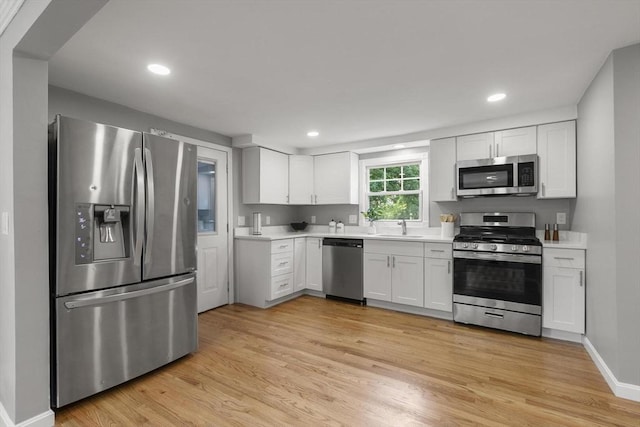 235 Groton Rd, Chelmsford, MA 01863 - kitchen with stainless steel appliances, a sink, light countertops, light wood-type flooring, and recessed lighting