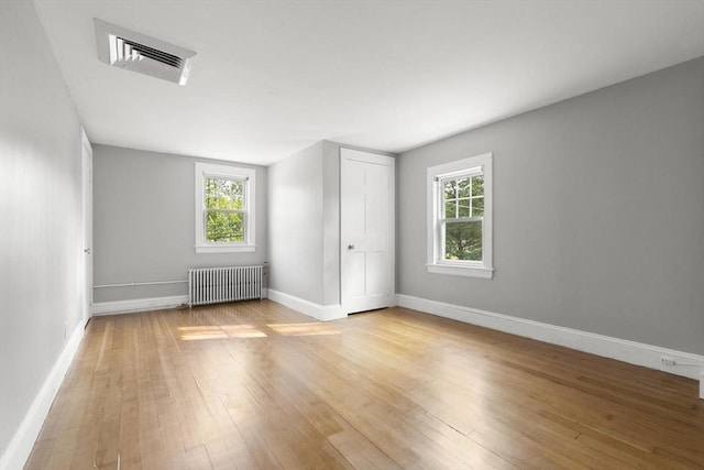 235 Groton Rd, Chelmsford, MA 01863 - unfurnished bedroom featuring radiator, light wood-style floors, and baseboards