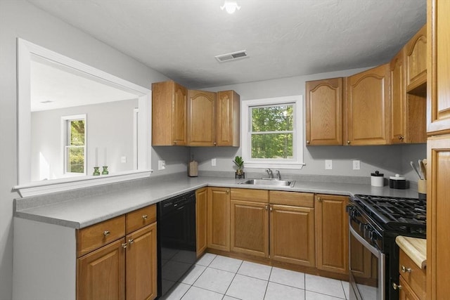 235 Groton Rd, Chelmsford, MA 01863 - kitchen featuring black dishwasher, gas stove, a sink, light tile patterned flooring, and brown cabinets