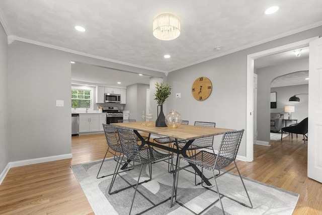 235 Groton Rd, Chelmsford, MA 01863 - dining area featuring arched walkways, light wood-style flooring, baseboards, crown molding, and recessed lighting