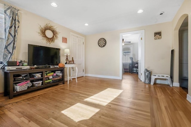 living room featuring ceiling fan and light hardwood / wood-style floors