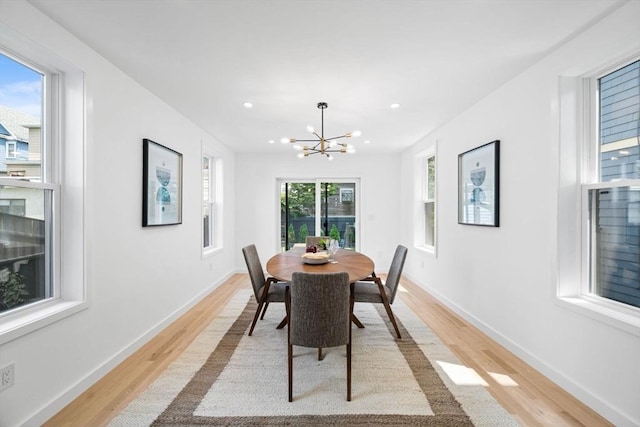 dining room with a notable chandelier and light wood-type flooring