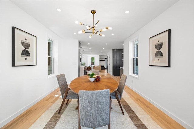 dining room with an inviting chandelier and light hardwood / wood-style flooring