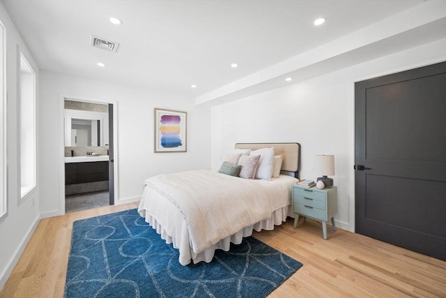 bedroom with wood-type flooring and ensuite bathroom