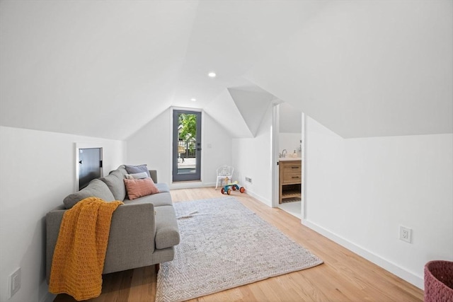 additional living space with wood-type flooring and vaulted ceiling