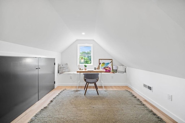 office with lofted ceiling and light hardwood / wood-style floors