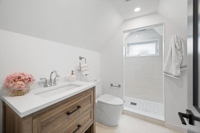 bathroom with vaulted ceiling, a tile shower, vanity, and toilet