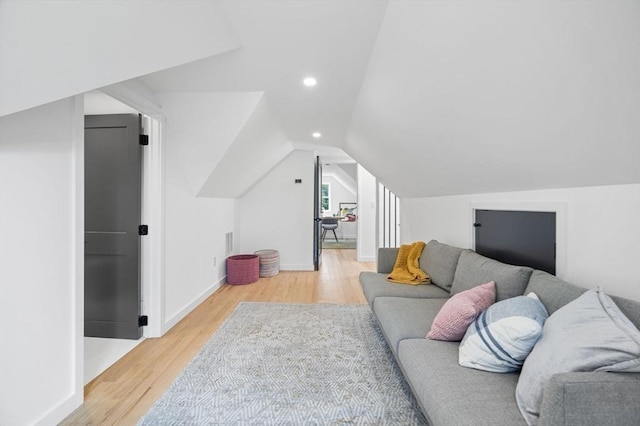 living room featuring lofted ceiling and light wood-type flooring