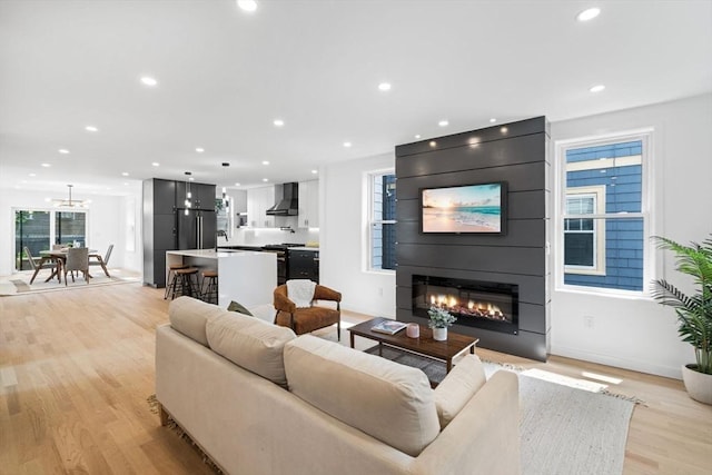 living room with light wood-type flooring, sink, and a fireplace