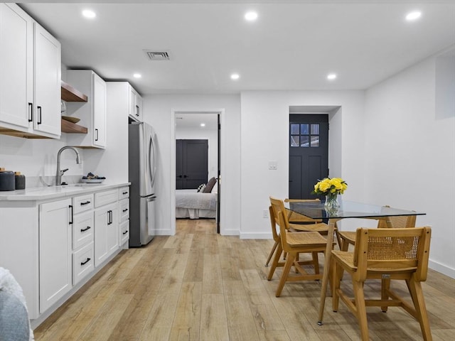 dining area with sink and light hardwood / wood-style flooring