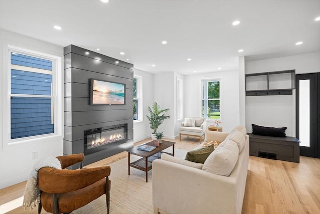 living room with a large fireplace and light wood-type flooring