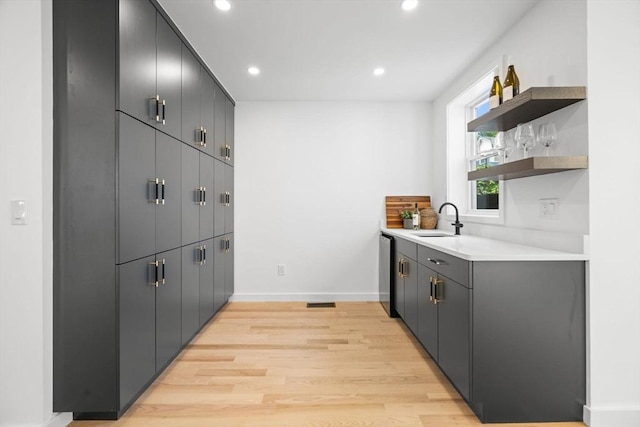 kitchen with sink, stainless steel dishwasher, and light hardwood / wood-style floors