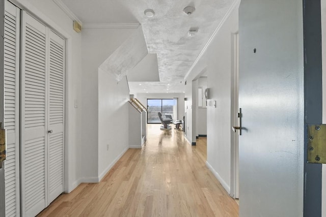 hallway with ornamental molding and light wood-type flooring