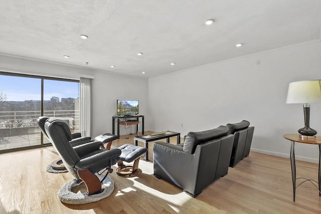 living room with crown molding and light hardwood / wood-style flooring